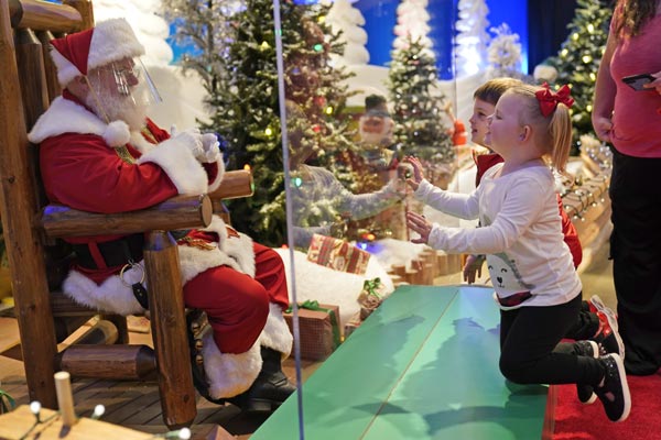 Santa Claus with face masks and plexiglass