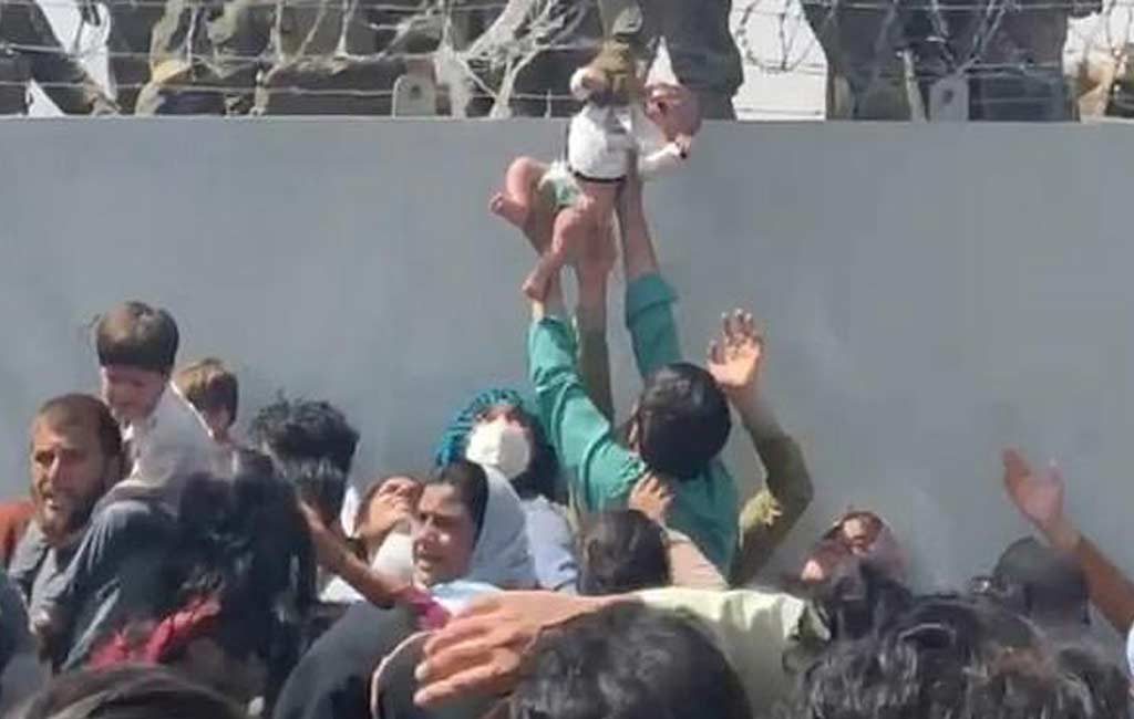 Baby passed over a wall at Kabul airport reunited with family