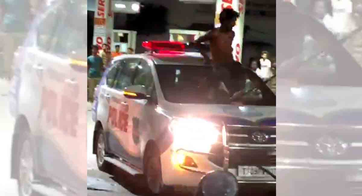 Watch: High on alcohol, man rides on roof of police vehicle