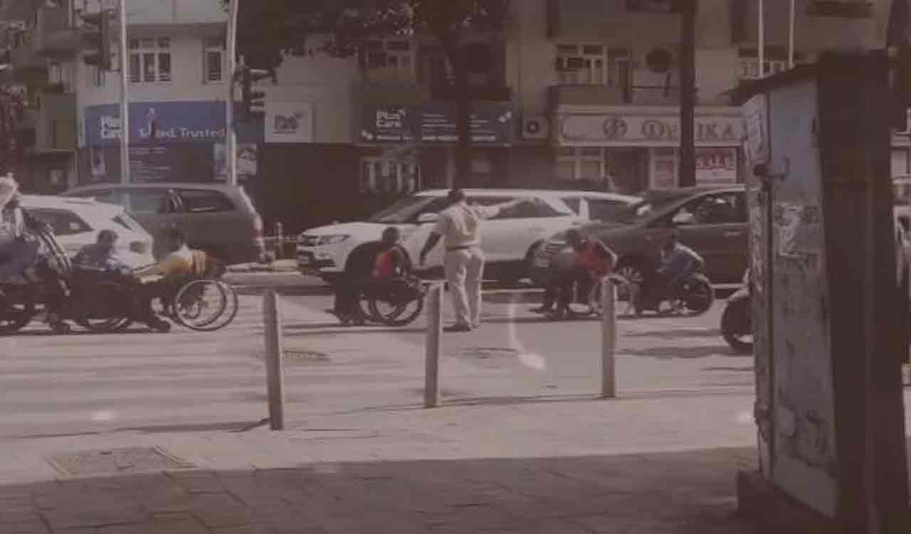 Watch: Policeman helps wheelchair-bound people cross busy road