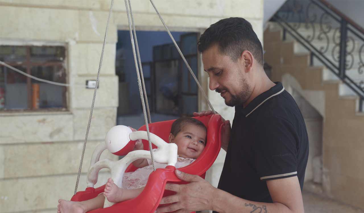 Syrian baby born under earthquake rubble turns 6 months, happily surrounded by her adopted family
