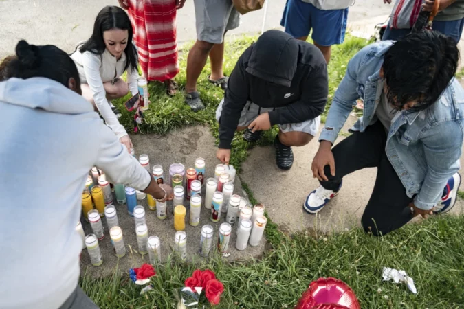 People light candles on the sidewalk during a vigil for 13-year-old Nyah Mway in Utica, N.Y