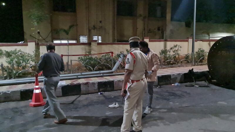 Police officers examine the scene of police firing in Nampally in Hyderabad