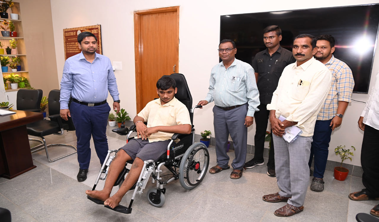 Mancherial Collector Kumar Deepak hands over Battery-run wheelchair to beneficiary