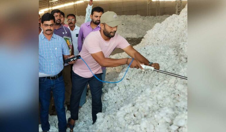 An employee testing moisture percentage in cotton at a ginning mill.