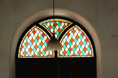 3.The colourful stain glass door top windows and sill glitter with the outside sun poring inside the church. [Photo Copyright N.Shiva Kumar]