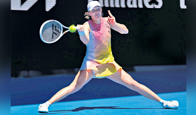 Iga Swiatek of Poland plays a forehand return to Emma Raducanu of Britain during their third round match at the Australian Open in Melbourne, on Saturday. Photo: AP