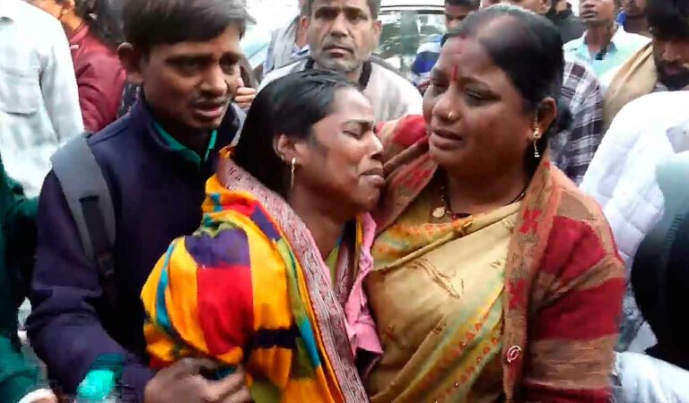 Relatives of victims wait outside the mortuary at the LNJP Hospital, in New Delhi, on Sunday.