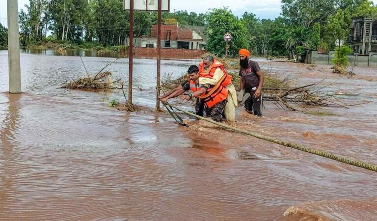 An Army Officer Of The Panther Division Carries A 60 Year Old Snake Bite Victim During An Evacuation Operation While Wading Through Floodwater At Ramdass, In Amritsar District, Punjab.