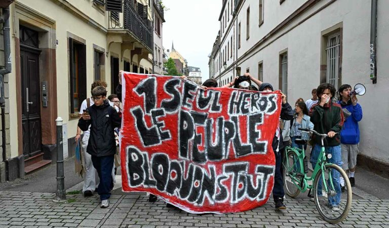 Protesters of the "Block Everything" movement march with a banner that reads, "one hero, the people, blocking everything" in Strasbourg, eastern France.
