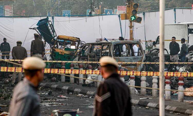 Charred remains of vehicles at a cordoned off area following a blast that occurred near Red Fort Metro Station on Monday.