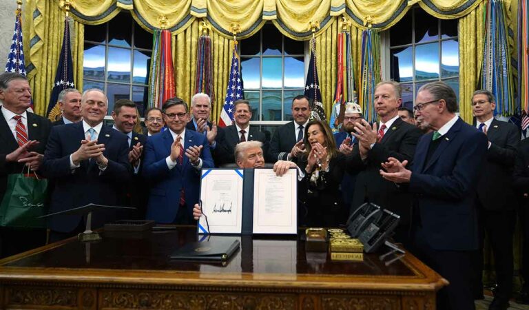 President Donald Trump displays the signed the funding bill to reopen the government, in the Oval Office of the White House.