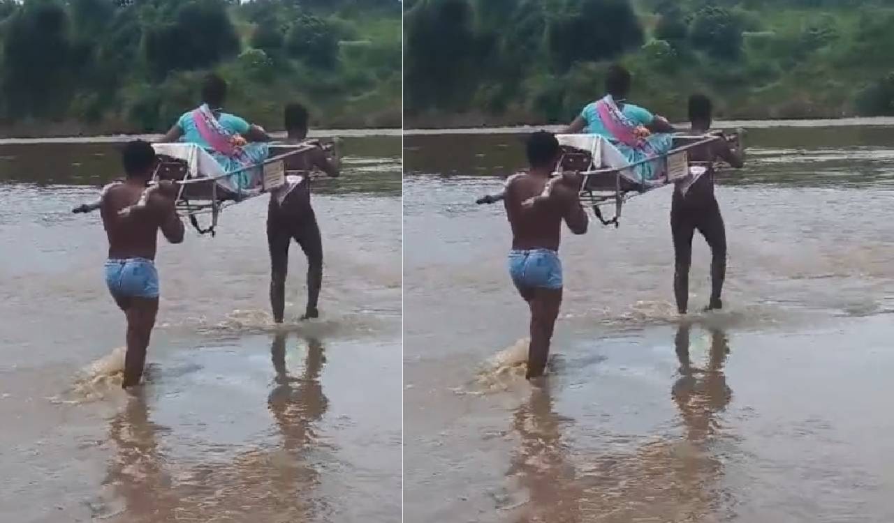 Tribals forced to wade through flooding stream carrying pregnant woman in Asifabad